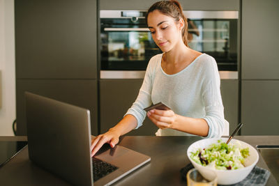 Young woman using mobile phone at home