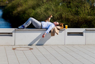 Young couple sitting on deck chair by water