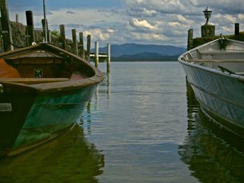 Boat moored on lake against sky