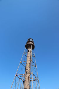 Low angle view of water tower against clear blue sky