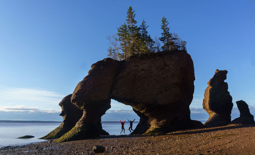 Friends jumping at hopewell rocks in new brunswick