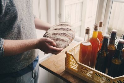 High angel view of hands holding homemade sourdough bread