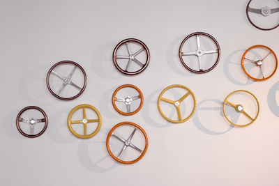 Close-up of various steering wheels mounted on wall