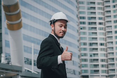 Young man standing in front of office building