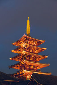 Illuminated temple against sky at dusk