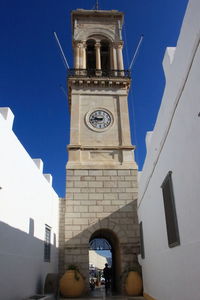 Low angle view of clock tower against blue sky
