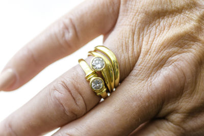 Cropped hand of woman wearing rings over white background