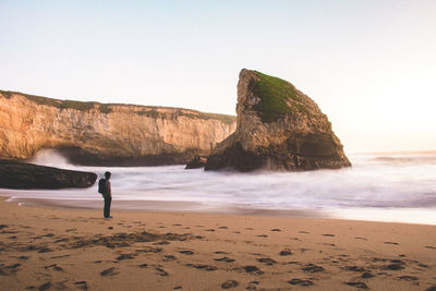 Rear view of man on beach against sky