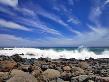 Scenic view of sea against blue sky and rocky coastline