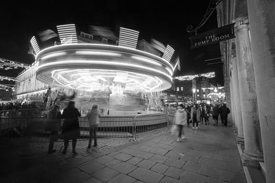 People in illuminated city at night