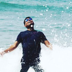 Young man surfing in sea