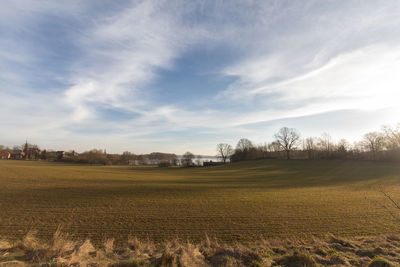 Scenic view of field against cloudy sky