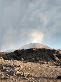 Smoke emitting from volcanic mountain against sky