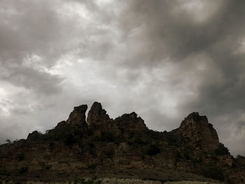 Low angle view of rock formations against sky