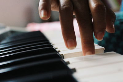 Close-up of hand playing piano