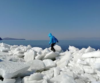 Girl walking on ice at beach