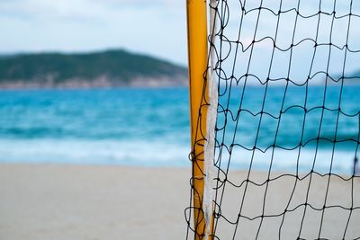 Close-up of net on sea against sky