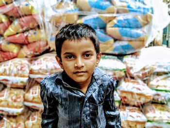 Portrait of boy against packages in store