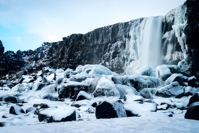 A long exposure of a waterfall in the snow covered hills at a thingvellir national park in iceland