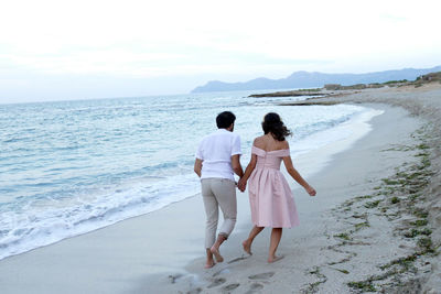 Rear view of women standing on beach