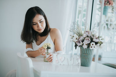 Woman holding flower at table