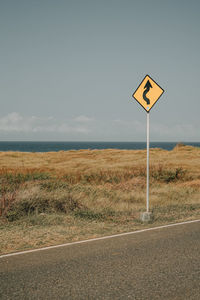 Road sign against clear sky