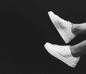 Low section of woman standing against black background