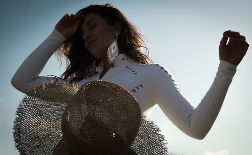 Low angle view of woman standing against sky