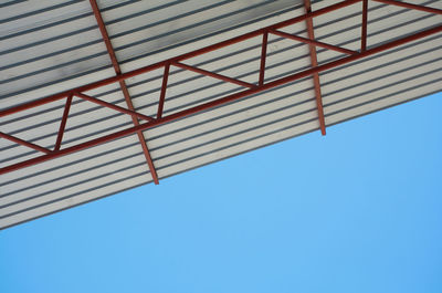 Low angle view of construction site against clear blue sky