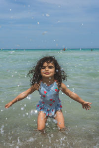 Portrait of girl splashing water in sea