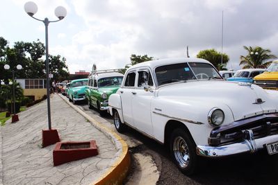 Cars on street in city against sky