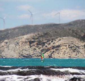 Man surfing on sea against sky