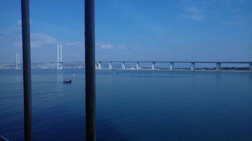 Bridge over sea against blue sky