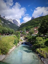 Scenic view of river amidst buildings against sky