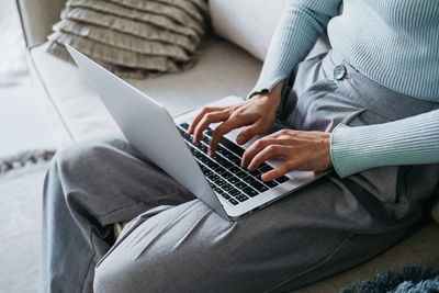 Beautiful woman on the couch working on a laptop.