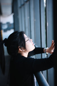 Side view of young woman looking at camera