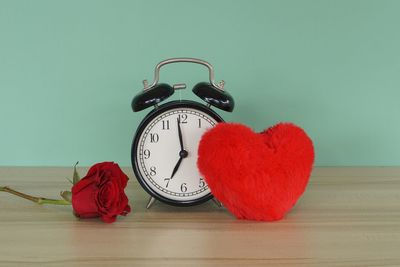 Close-up of clock on table against wall at home