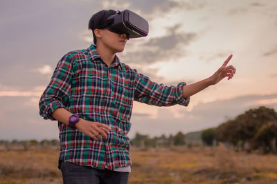 Man in tartan shirt wearing virtual reality headset reality in the beautiful sky technology concept