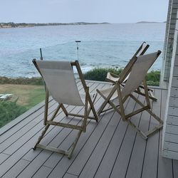 Deck chairs on beach against sky
