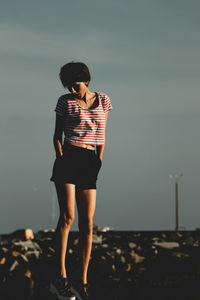 Full length of woman standing on beach against sky