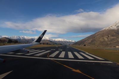 Airplane on runway against sky