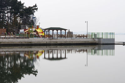 Built structure by lake against sky