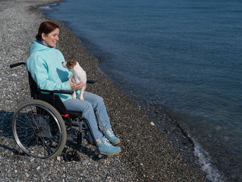 Side view of woman sitting on beach