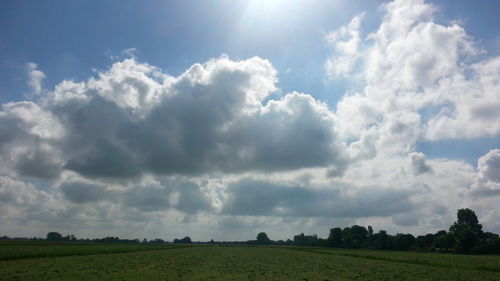 Scenic view of field against cloudy sky