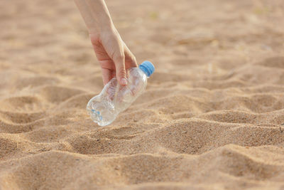 Close-up of water bottle at beach