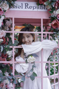 Rear view of woman standing by fence