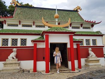 Woman standing outside temple against building