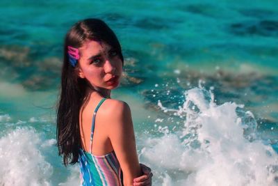 Portrait of young woman standing in swimming pool