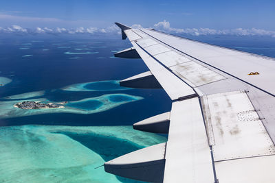 Airplane flying over sea against sky