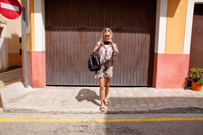 Full length portrait of woman on footpath